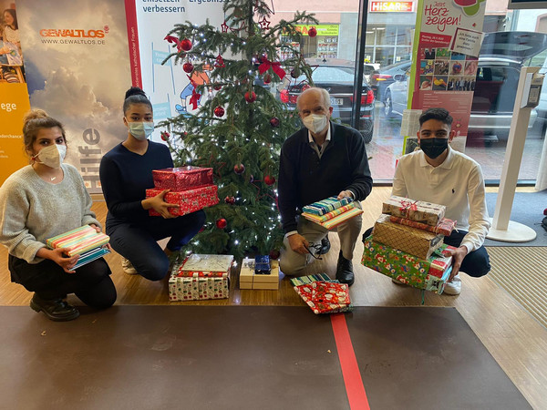 Übergabe der Geschenke im Monikahaus Die SV und die Schulleitung vor einem Weihnachtsbaum